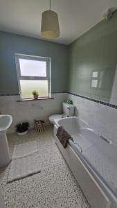 a bathroom with a tub and a toilet and a sink at Ocean Heights House in Dunfanaghy +17 photos