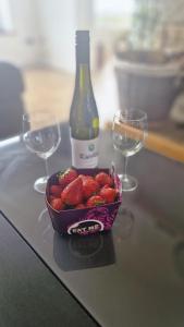 a bowl of strawberries and two wine glasses on a table at Ocean Heights House in Dunfanaghy