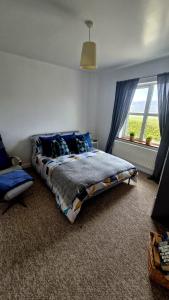 a bedroom with a large bed and a window at Ocean Heights House in Dunfanaghy