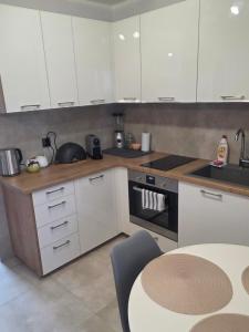 a kitchen with white cabinets and a table in it at Siódme niebo in Gdańsk