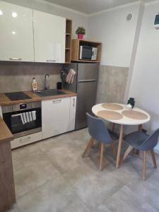 a kitchen with a table and two chairs and a sink at Siódme niebo in Gdańsk