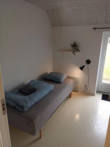 a bedroom with a bed and a lamp and a window at Sønderhedens B&B in Vrå