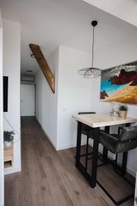 a dining room with a table and a painting on the wall at vredehof appartement in Sint Maartensbrug