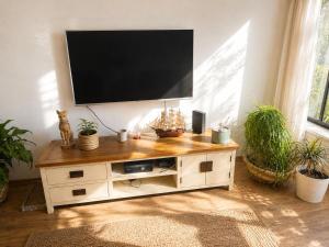 a flat screen tv on top of a wooden entertainment center at Cozy flat near park in Netanya