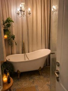a bath tub in a bathroom with a chandelier at Cozy flat near park in Netanya +62 photos
