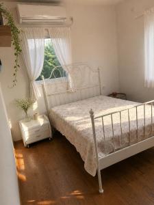 a bedroom with a white bed and a window at Cozy flat near park in Netanya