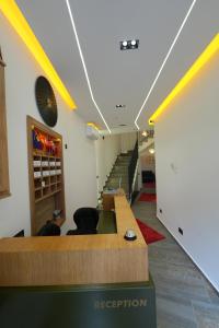 a lobby of a hospital with a reception desk and stairs at Hotel Besfort in Prizren