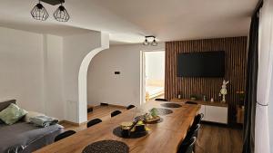 a living room with a wooden table and a television at Chata Pod Skarpą in Wieprzec