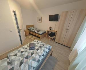 a room with two beds and a television in it at NEU Monteurhaus und Ferienhaus 5 Betten Parkplatz 24h Checkin in Alsdorf