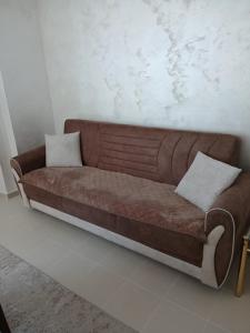 a brown couch with two white pillows on it at Vendetta Montenegro in Risan