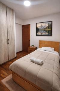 a bedroom with a large bed and a cabinet at Amatista Apartment in Cusco