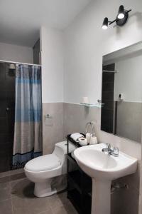 a bathroom with a white toilet and a sink at Amatista Apartment in Cusco