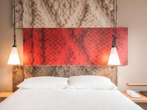 a bedroom with a white bed and two lights at ibis Orleans Centre Gare in Orléans