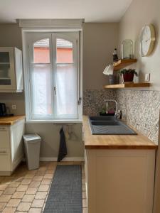 a kitchen with a sink and a window at Le Cocon Turckheim in Turckheim