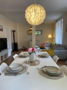 a dining room with a table with plates and wine glasses at Le Cocon Turckheim in Turckheim