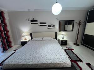 a bedroom with a large bed and two night stands at SunBeach Apartament in Golem +10 photos