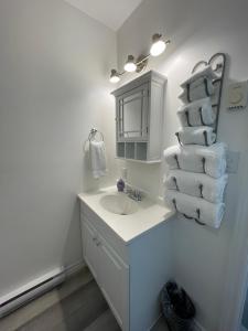 a bathroom with a sink and a stack of towels at Riverfront Studios Inn in Sault Ste. Marie