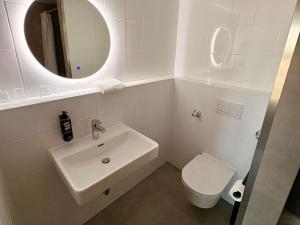 a bathroom with a sink and a toilet and a mirror at ibis Hotel Nürnberg Altstadt in Nuremberg