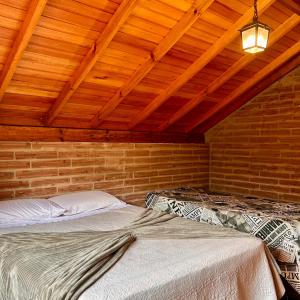 a bedroom with two beds in a room with wooden ceilings at Villetta Gramado Roma in Gramado