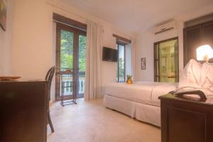 Schlafzimmer mit einem Bett, einem TV und einem Fenster in der Unterkunft Hotel Monterrey in Cartagena de Indias