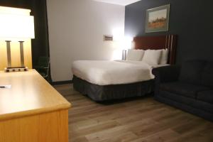 a hotel room with a bed and a couch at Colonial Inn in Brandon +16 photos