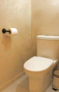 a bathroom with a toilet and a roll of toilet paper at Réveil face à la mer - Plage à 2 min - Résidence calme in Gourbeyre