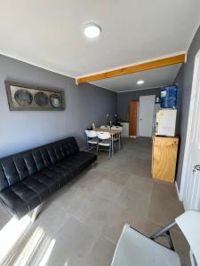 a living room with a black couch and a table at Hostal JVDepartamento B in Nogales