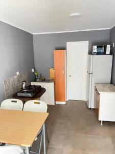 a kitchen with a table and chairs and a refrigerator at Hostal JVDepartamento B in Nogales +2 photos