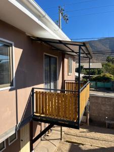 a porch with a wooden railing on a house at Hostal JVDepartamento B in Nogales