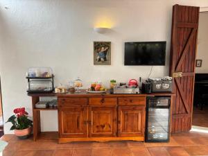 a kitchen with a counter with a tv on the wall at B&B De Janas in La Caletta