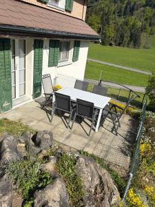 a picnic table and chairs on a patio at Ferienwohnung Bürgenblick in Kehrsiten