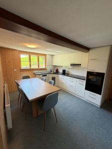 a kitchen with a table and chairs in a room at Ferienwohnung Bürgenblick in Kehrsiten