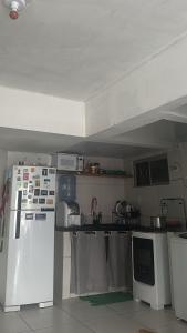 a kitchen with a white refrigerator and appliances at Quarto Astral in Recife