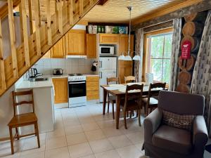 a kitchen with a table and a dining room at Usva Cabins Ylläs - Sapara J 38 in Äkäslompolo