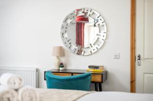 a bedroom with a mirror above a desk with a blue chair at Central Basement Flat-Parking-By FabAccommodation in Bristol