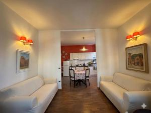 a living room with two white couches and a table at La Specola di Galileo con ampia vasca idromassaggio in Acquasparta