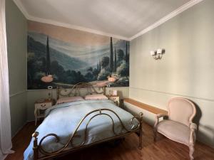 a bedroom with a painting and a bed and a chair at La Specola di Galileo con ampia vasca idromassaggio in Acquasparta +17 photos