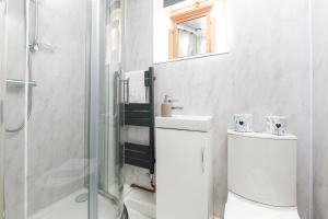 a white bathroom with a toilet and a shower at Central Basement Flat-Parking-By FabAccommodation in Bristol +14 photos