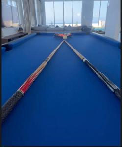 two cue sticks on top of a pool table at شاليهات الجوهرة in Fins