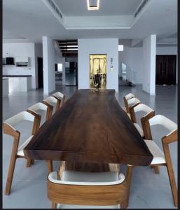 a wooden table with chairs around it in a room at شاليهات الجوهرة in Fins