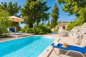 a pool with a table and chairs and an umbrella at Millers Cottage Large Private Pool AC WiFi in Vlachopoulátika