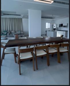 a dining room with a large wooden table and chairs at شاليهات الجوهرة in Fins