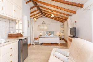 a kitchen and living room with a bed in the background at Millers Cottage Large Private Pool AC WiFi in Vlachopoulátika