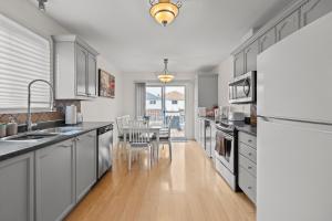 a kitchen with stainless steel appliances and a dining room at 3 Bedroom suite Upper Level of House 8 guests in Barrie