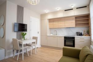 a kitchen and living room with a table and chairs at Apartament Daisy II Pszczyna Centrum in Pszczyna