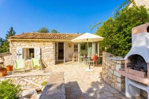 a stone house with a patio and an outdoor oven at Millers Cottage Large Private Pool AC WiFi in Vlachopoulátika