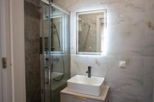 a bathroom with a sink and a glass shower at Apartament Daisy II Pszczyna Centrum in Pszczyna +14 photos