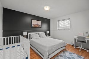 a bedroom with a white bed and a black wall at 3 Bedroom suite Upper Level of House 8 guests in Barrie