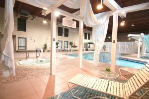a pool with a bench and a tub in a building at Colonial Inn in Brandon