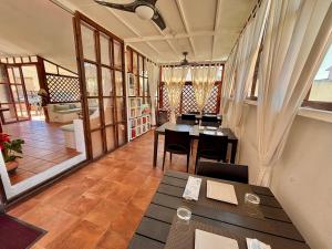 a room with a table and chairs and a living room at B&B De Janas in La Caletta